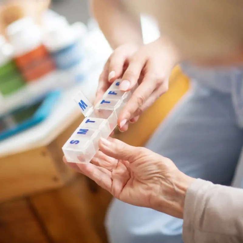 Caregiver helping senior review medication reminder card, calendar, or helping with meal prep